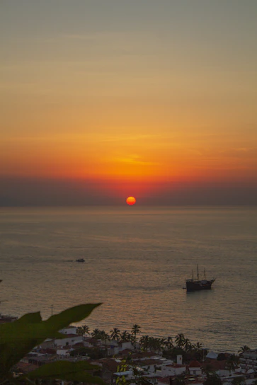 A vibrant photo of a sunset over Puerto Vallarta's coastline with a group enjoying a guided tour.