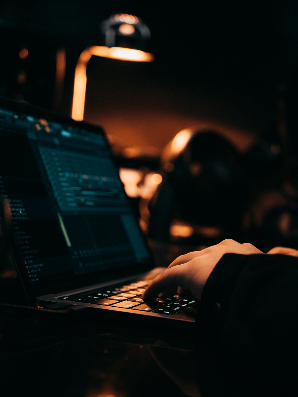 a person typing on a laptop in a dark room