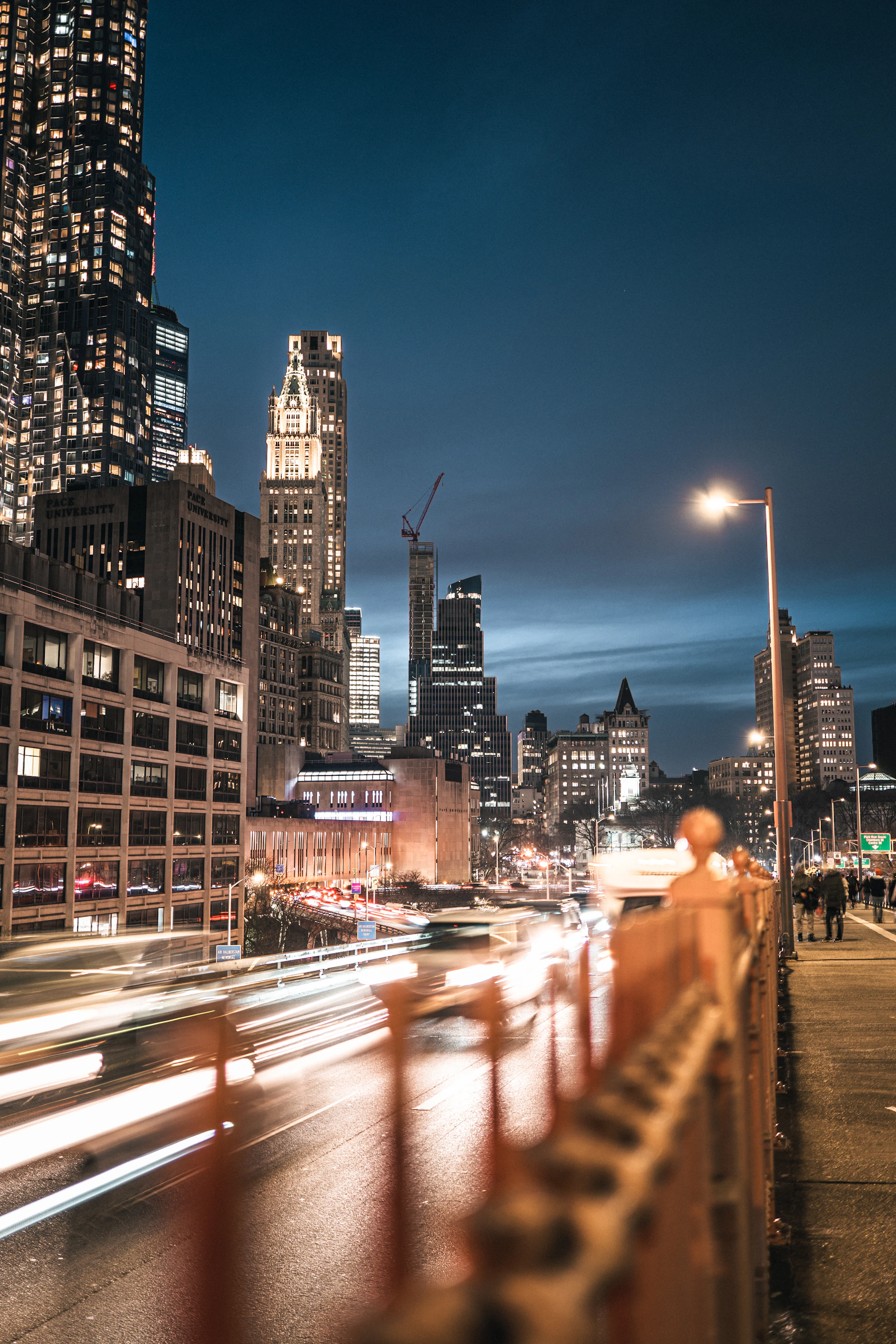 A wide-angle shot of a bustling city street at dusk, with vibrant lights and candid moments.