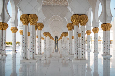 a white and gold building with columns and arches