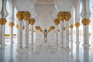 a white and gold building with columns and arches