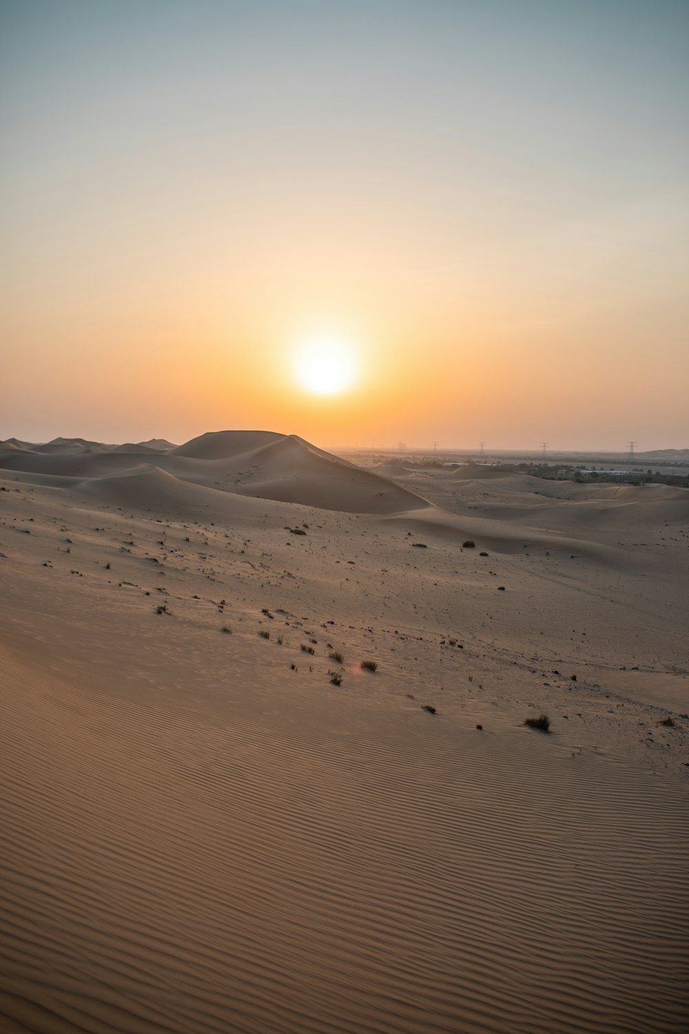 the sun is setting over the sand dunes