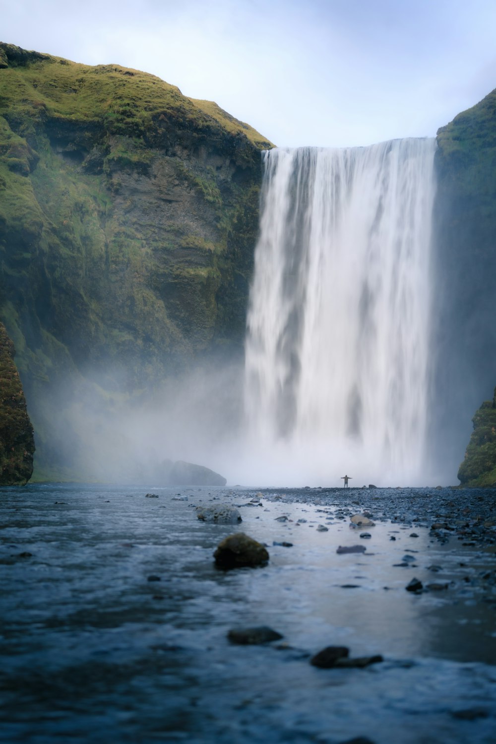 a man standing in front of a waterfall