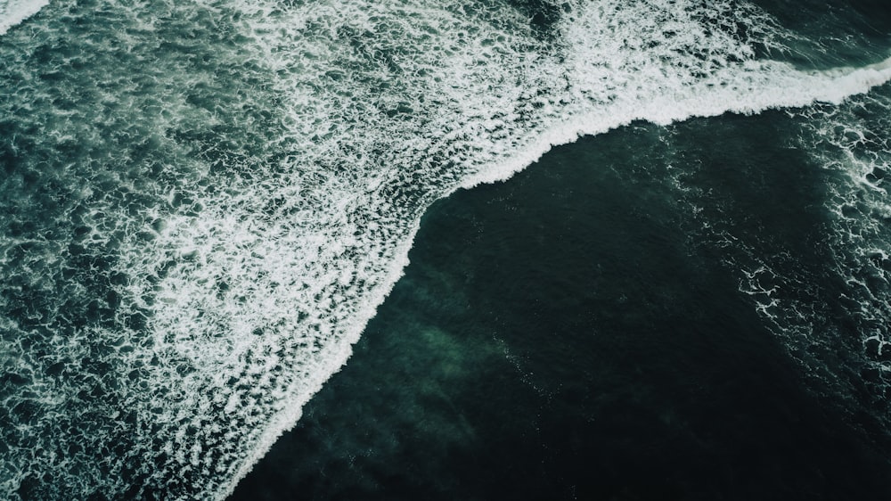 an aerial view of the ocean with waves