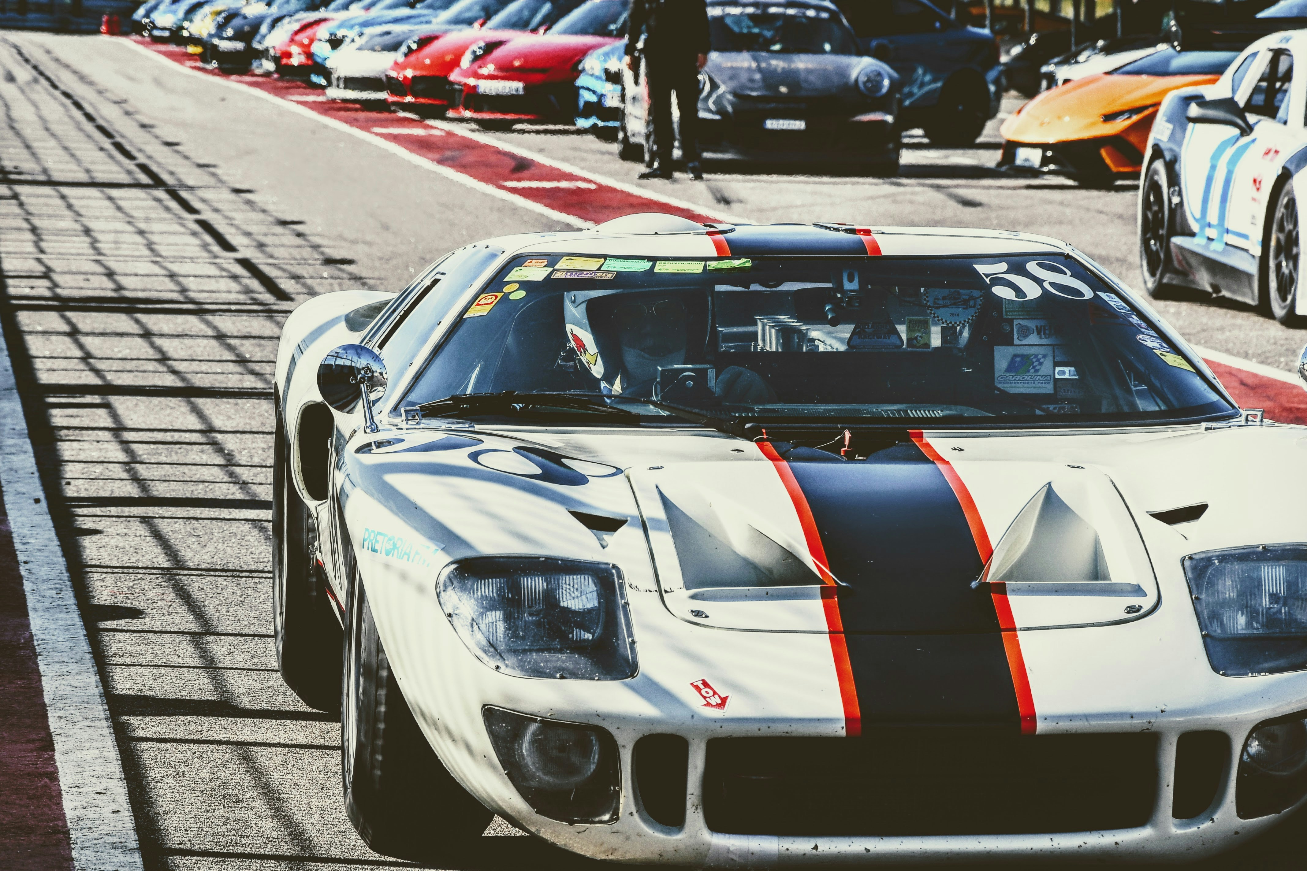 A white race car driving down a race track photo – Free Pitlane Image ...