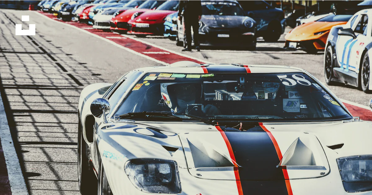 A white race car driving down a race track photo – Free Pitlane Image ...