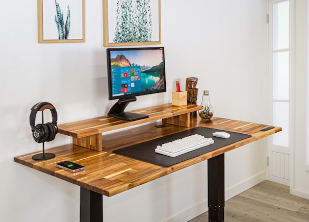 A sleek desktop setup with a modern monitor and keyboard on a wooden desk.