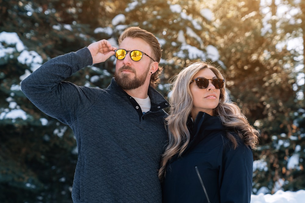 um homem e uma mulher estão de pé na neve