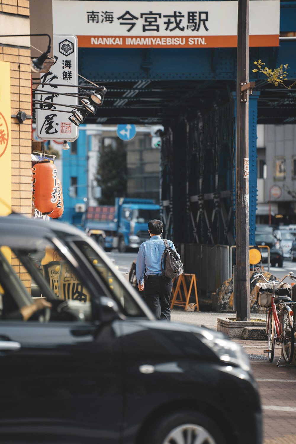 a man walking down a street next to a car