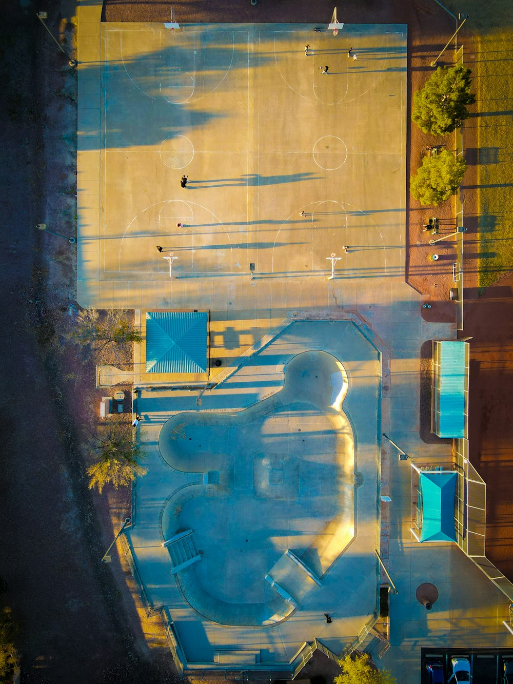 an aerial view of a parking lot and a basketball court