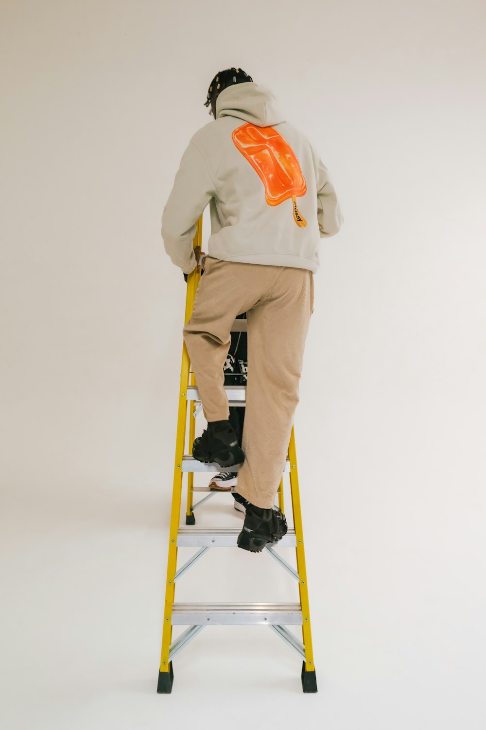 a man sitting on a yellow step ladder