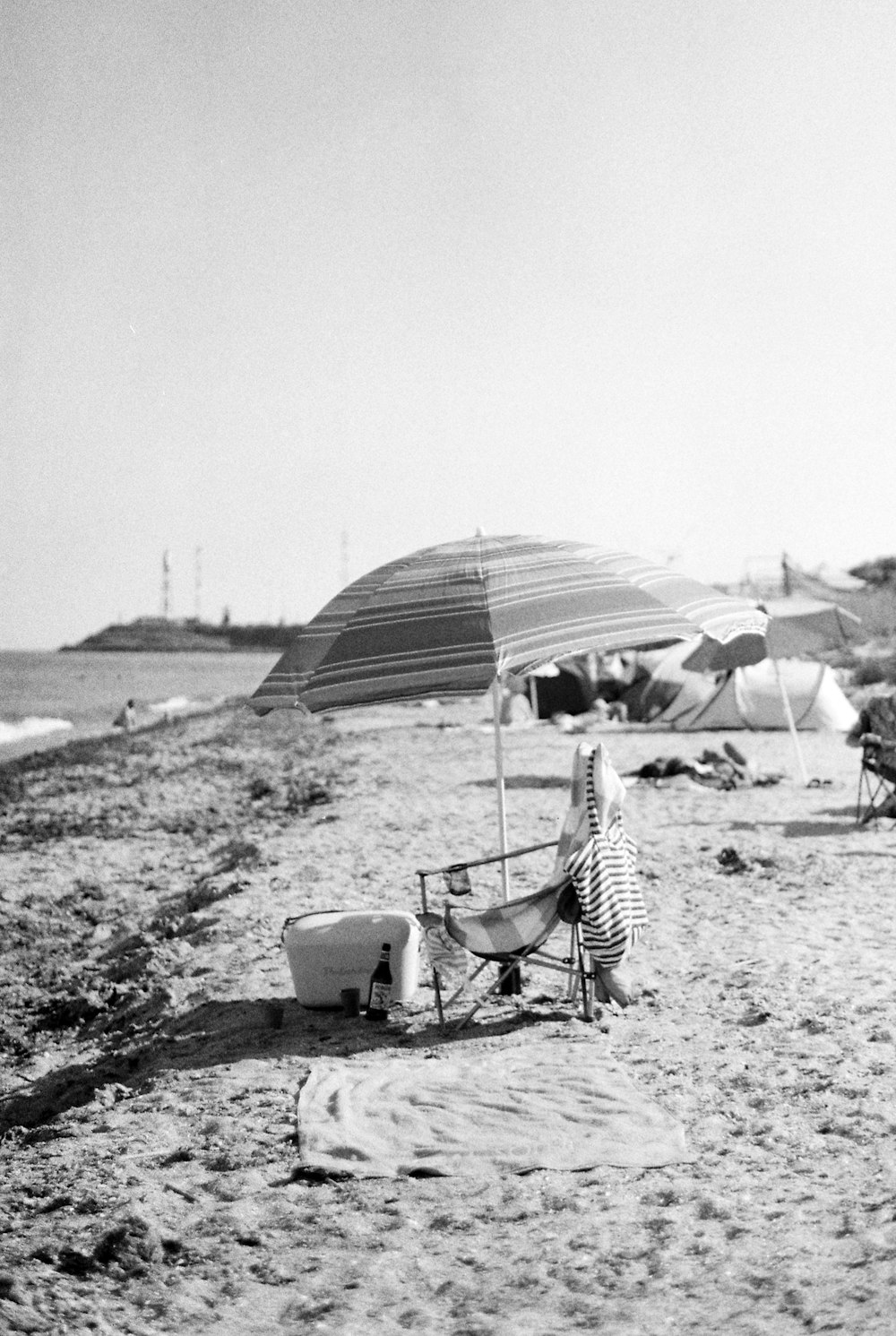 a black and white photo of a beach with umbrellas