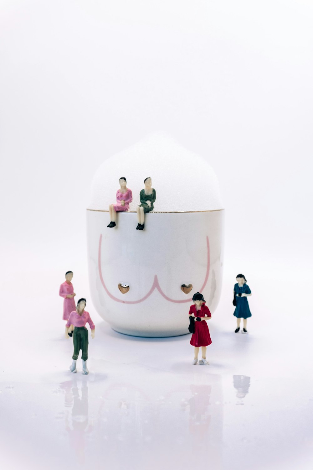 a group of miniature people sitting on top of a bowl