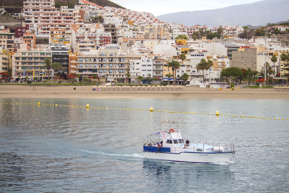 a boat traveling on the water in front of a city