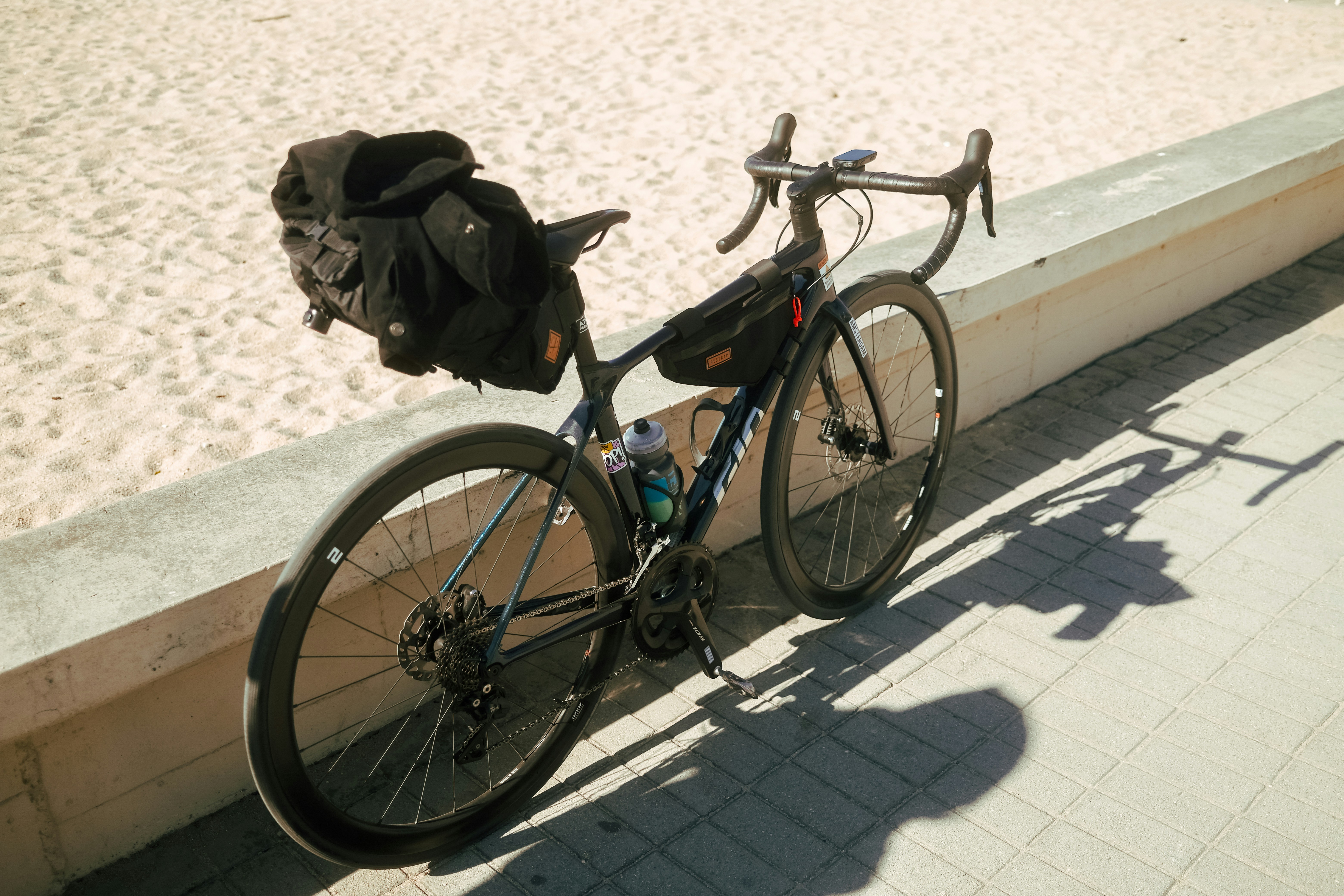 a bike parked on the side of a beach