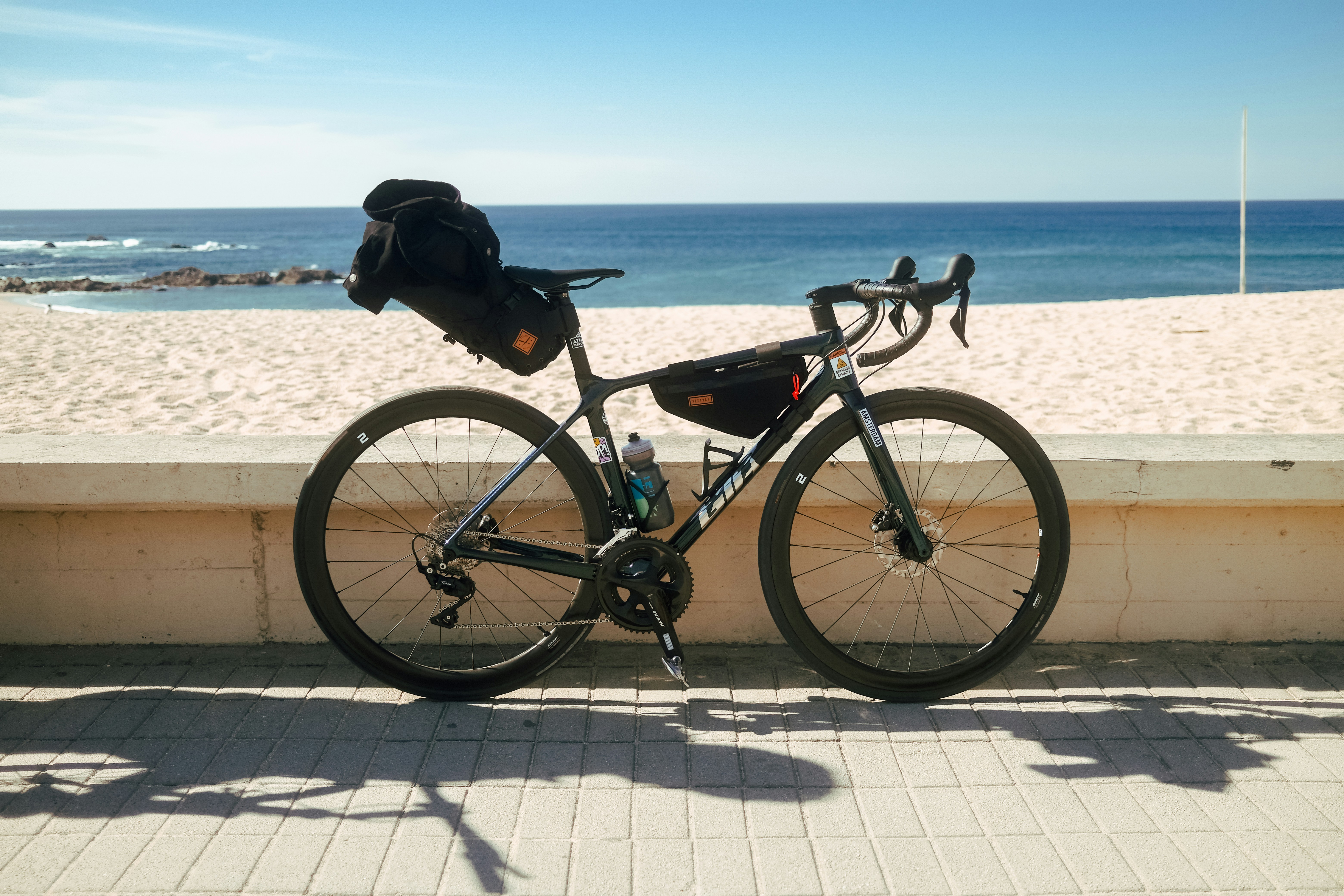 a bicycle parked on the side of a beach