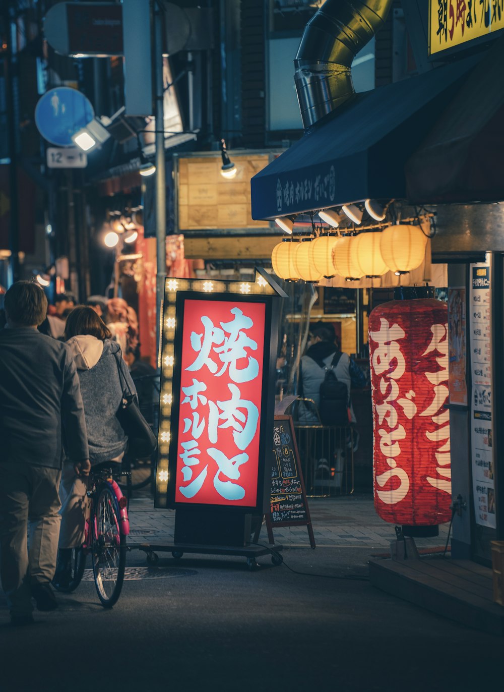 a man riding a bike down a street next to a sign