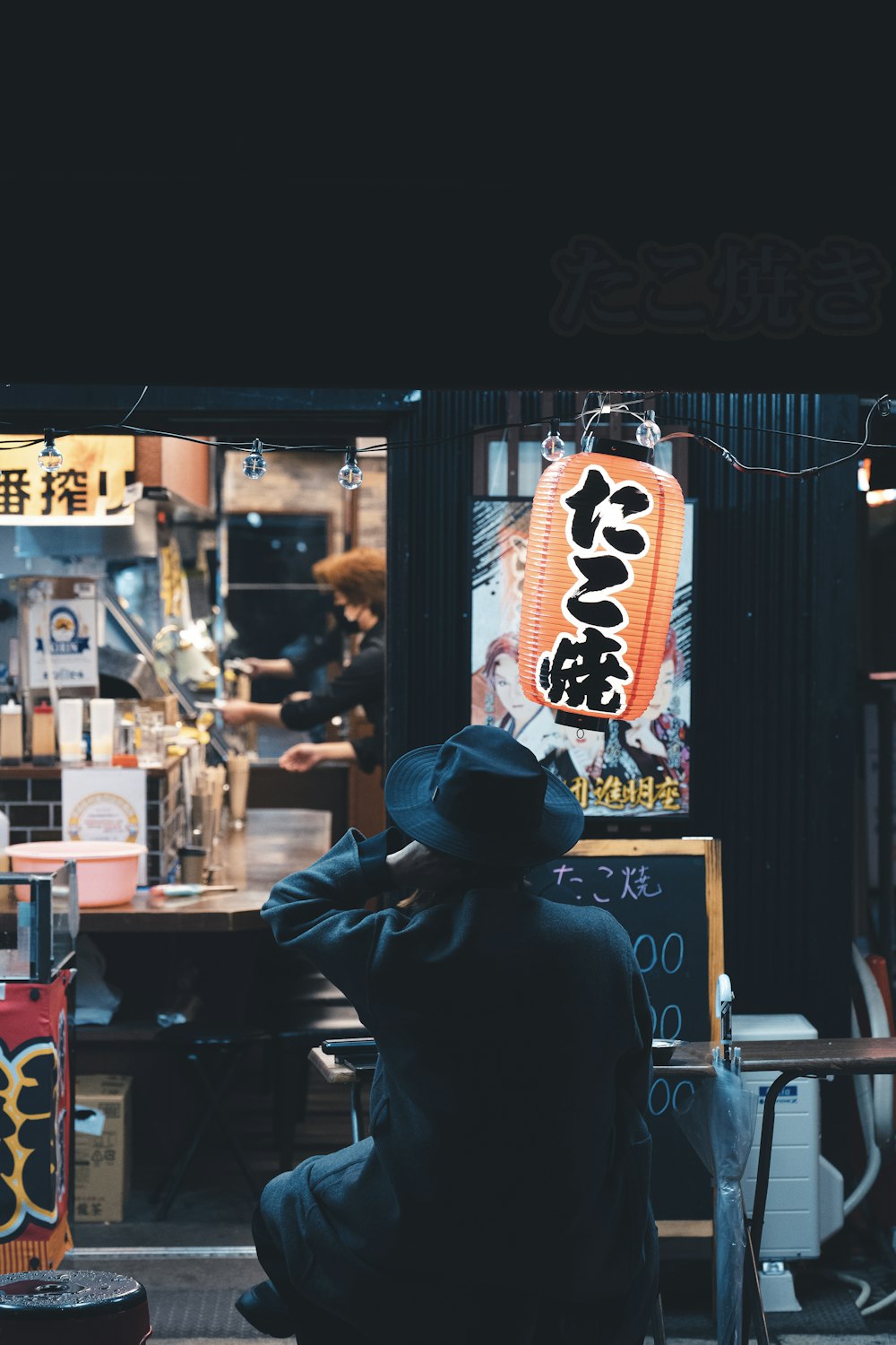 a man sitting on the ground in front of a store