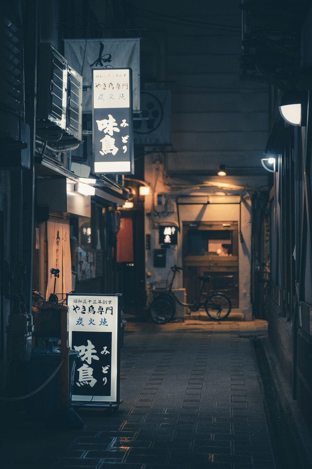 天井から看板がぶら下がっている狭い路地