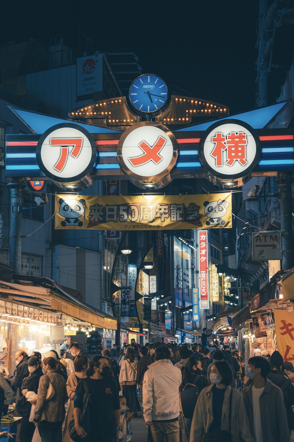 a group of people walking down a street next to tall buildings