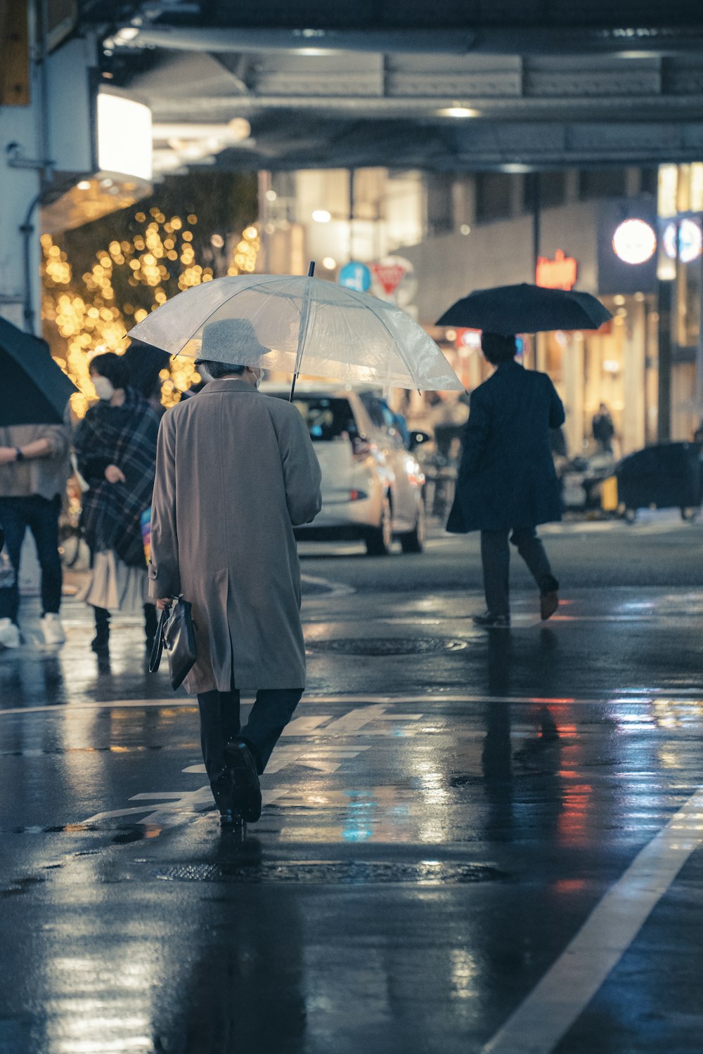 um grupo de pessoas andando por uma rua segurando guarda-chuvas