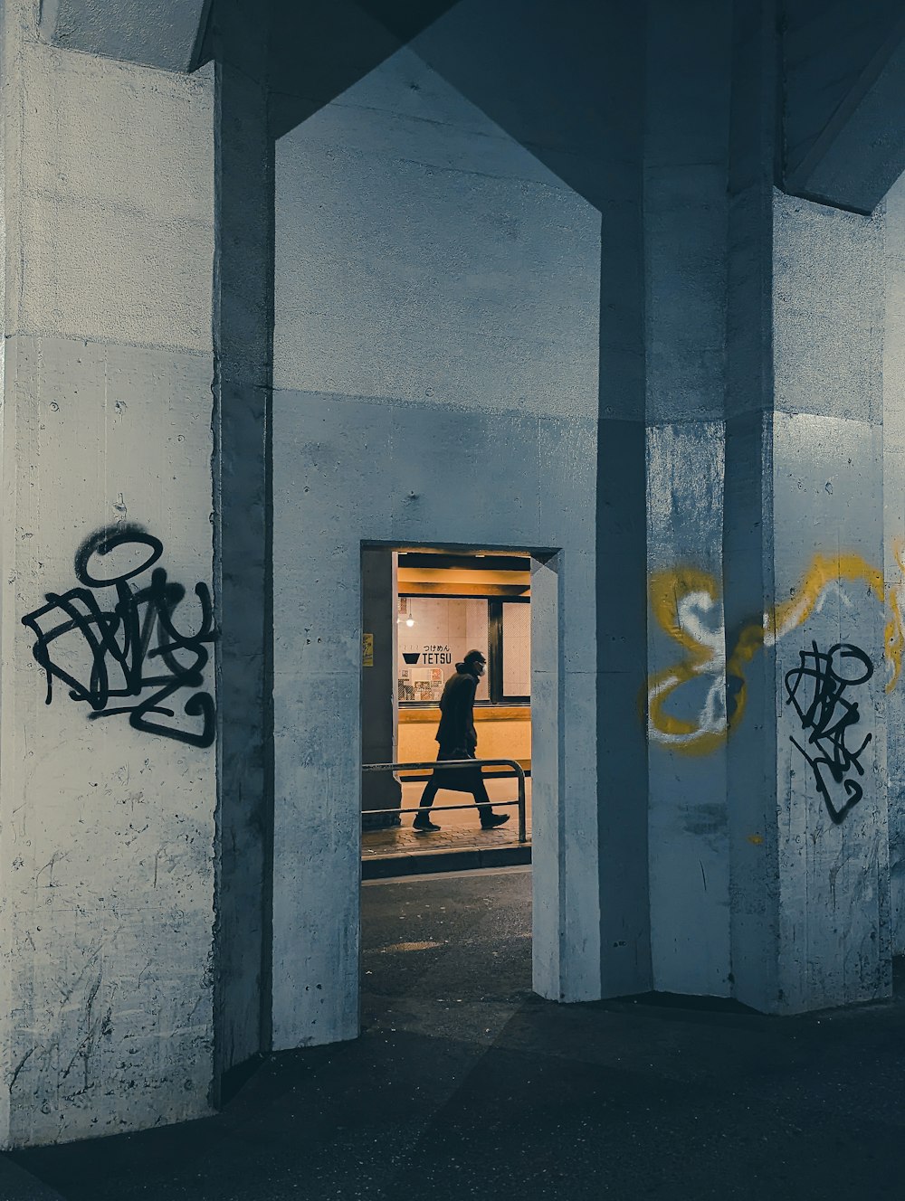 a person walking through a doorway with graffiti on the walls