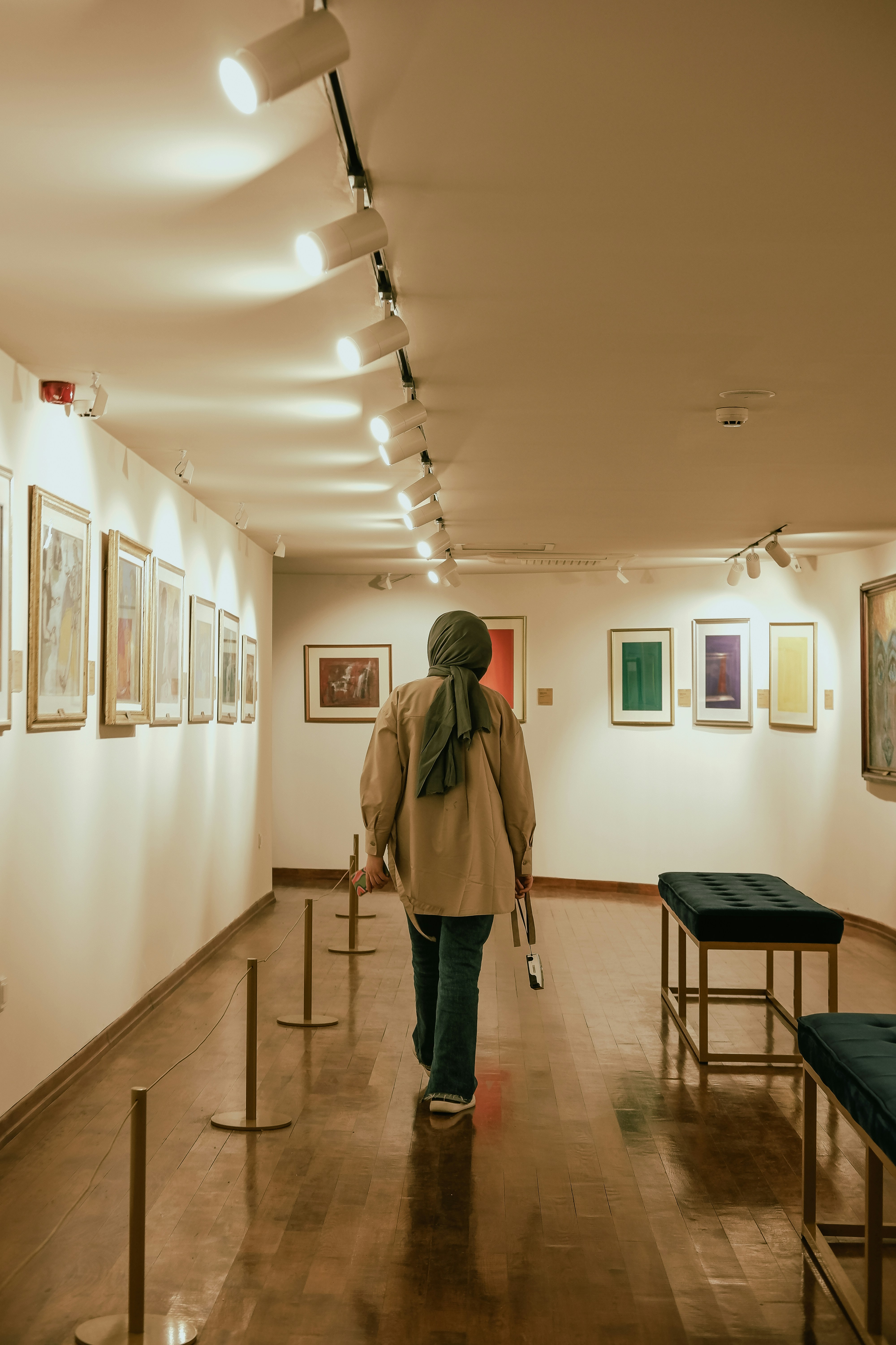 a woman walking down a hallway with a cane