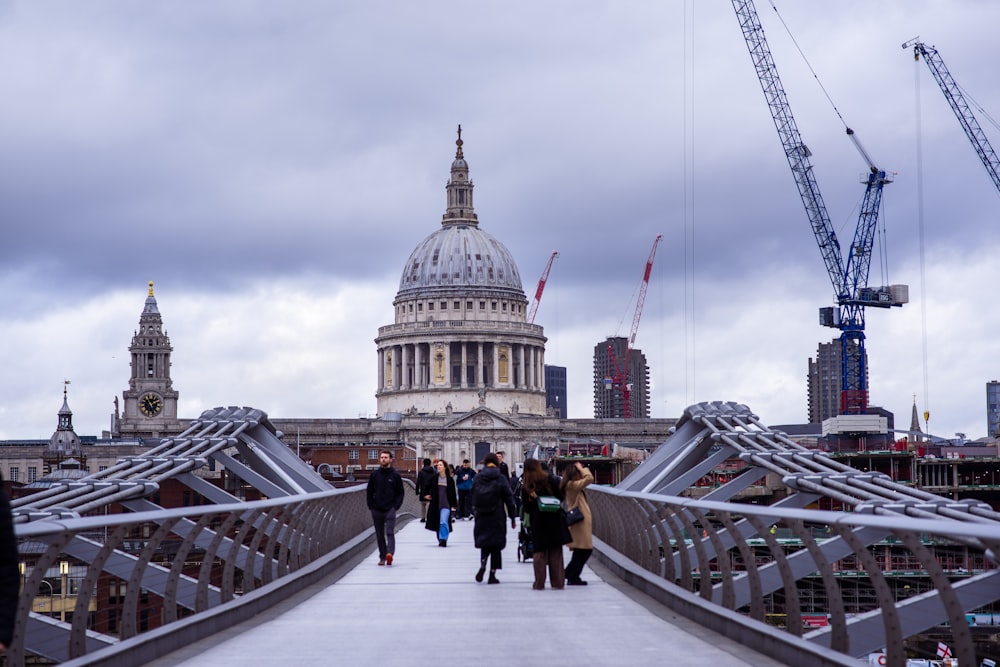 a group of people walking across a bridge