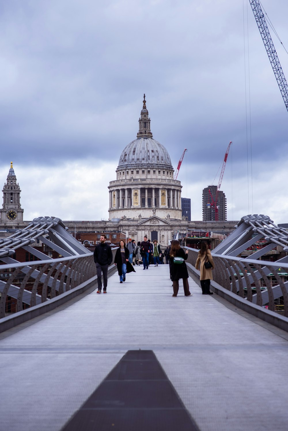 a group of people walking across a bridge