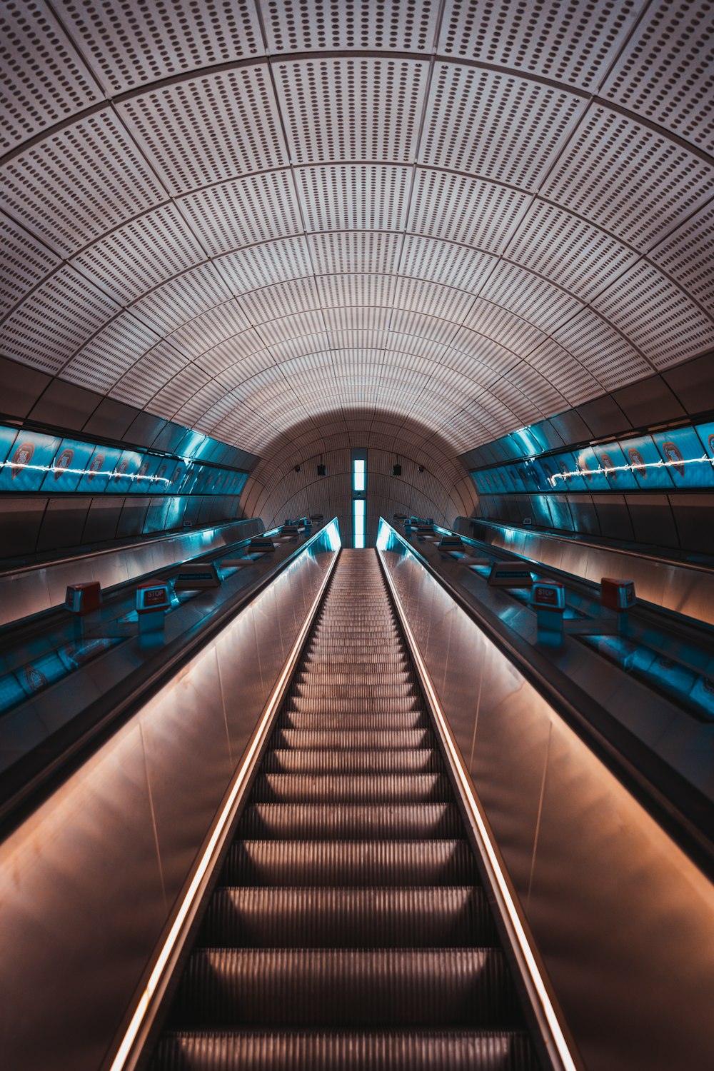 an escalator in a subway station with blue lights