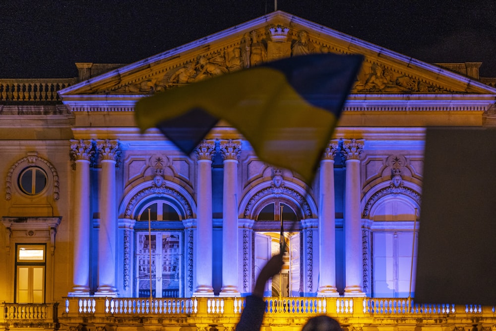 a person holding a flag in front of a building