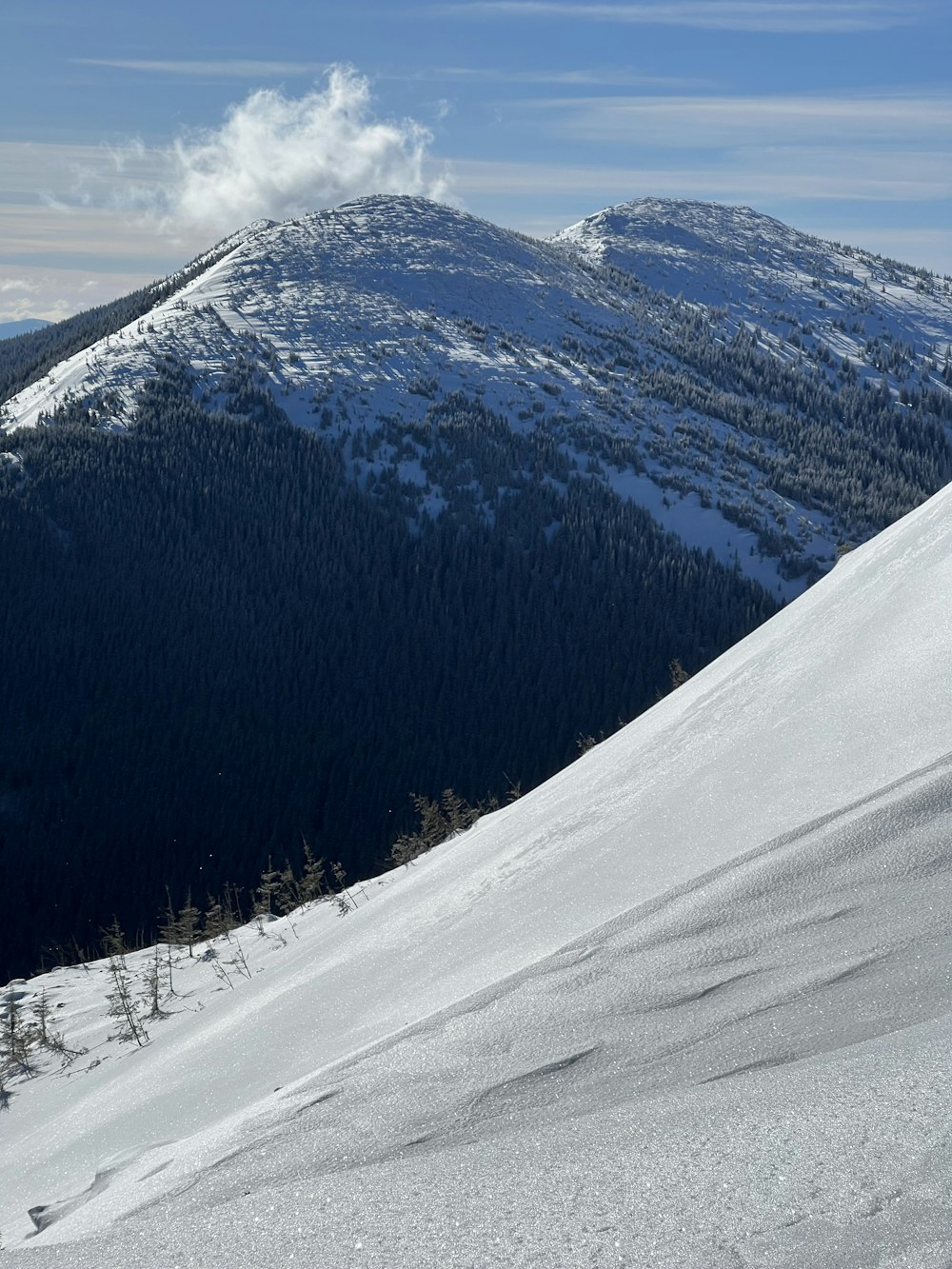 a man riding skis down the side of a snow covered slope