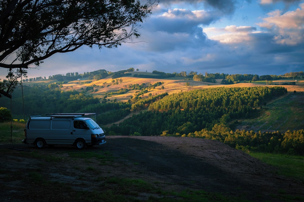 a van parked on top of a dirt road