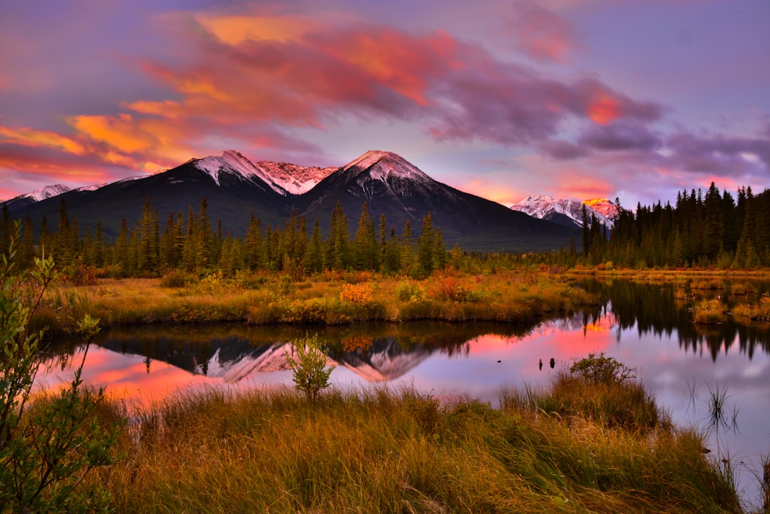 a beautiful sunset over a mountain with a lake in the foreground, Autumn sunrise at the Vermillion lakes Banff national 