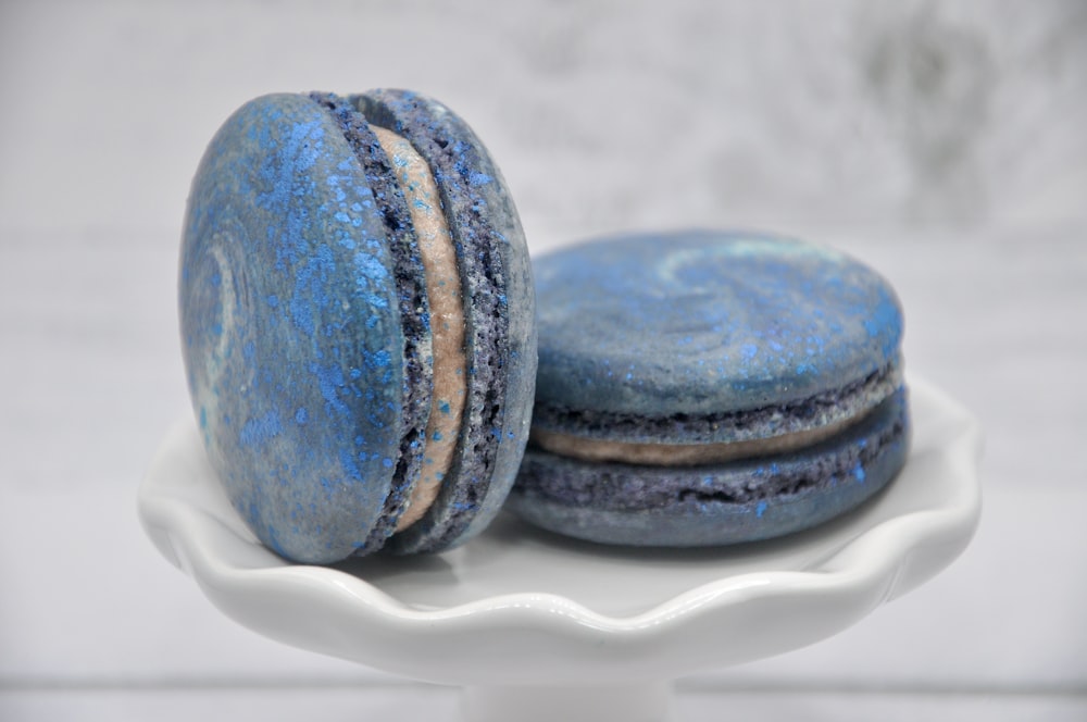 deux macarons bleus et blancs sur une assiette blanche