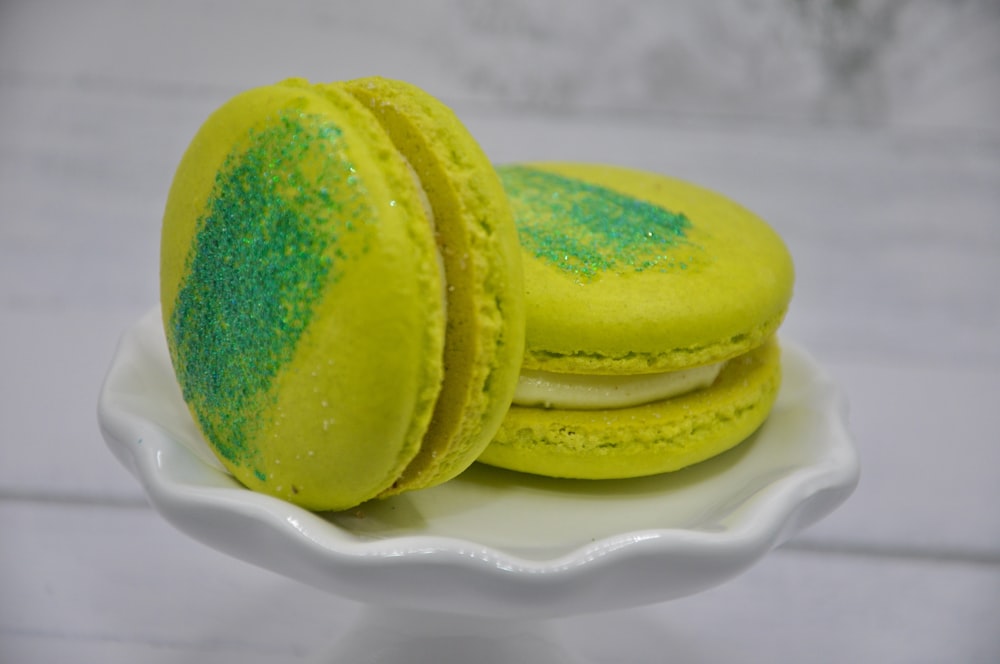 dois macarons amarelos e verdes em uma placa branca