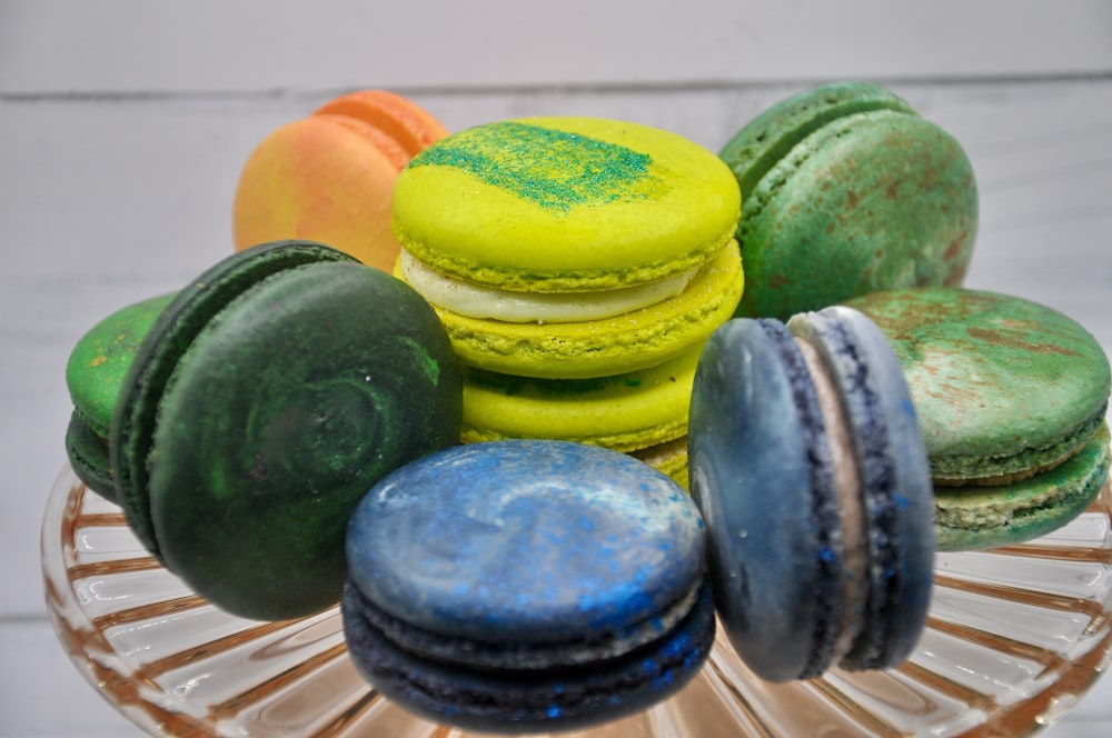 a glass bowl filled with different colored macaroons