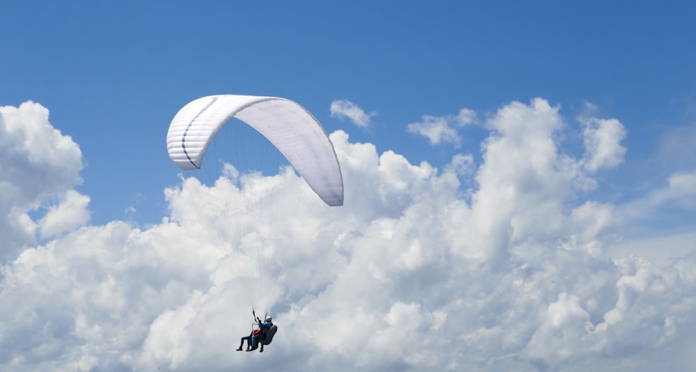 a person is parasailing in the sky on a cloudy day