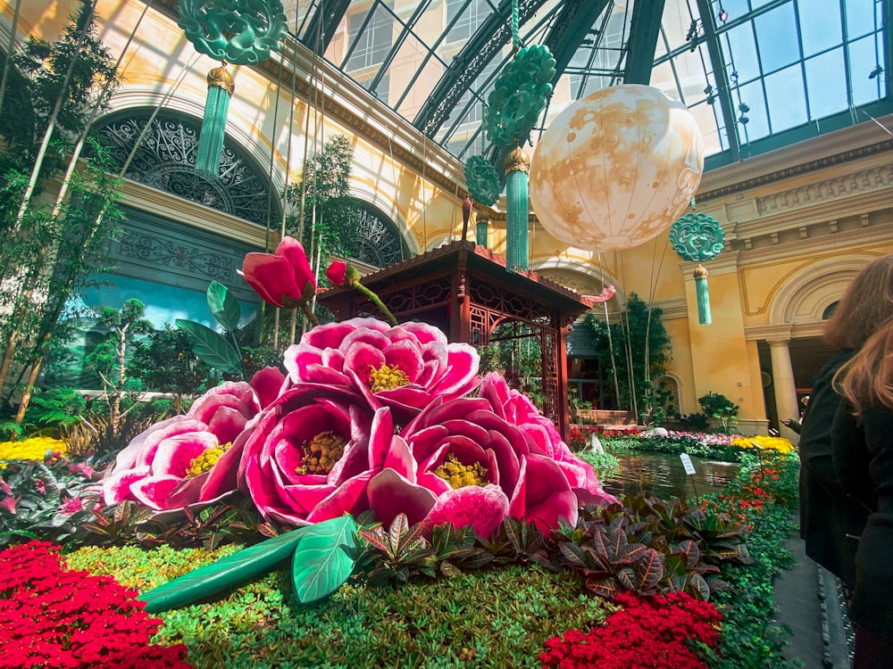 a woman standing in front of a display of flowers