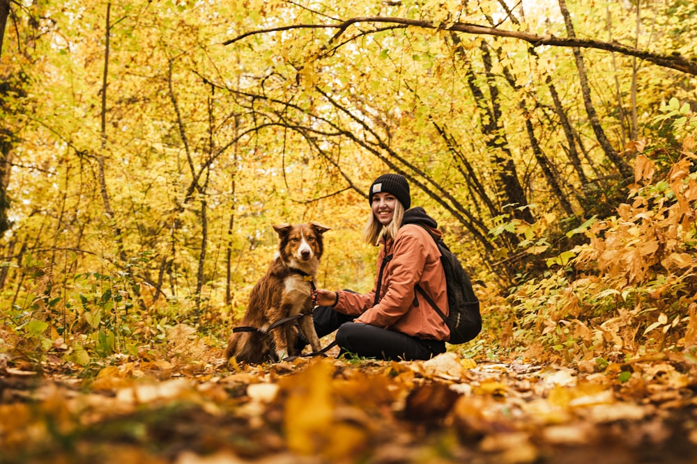 a woman sitting on the ground with her dog