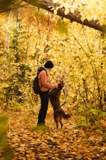 a person with a backpack and a dog in the woods