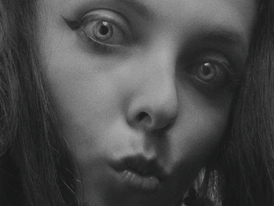 Close-up of a model’s eyes sparkling with personality, framed by black shadows.