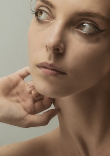 a woman is posing for a picture with her hand on her face