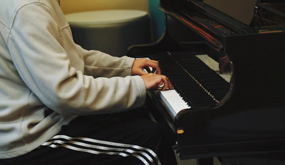 Jaiden playing piano under warm stage lighting in an intimate jazz lounge setting.