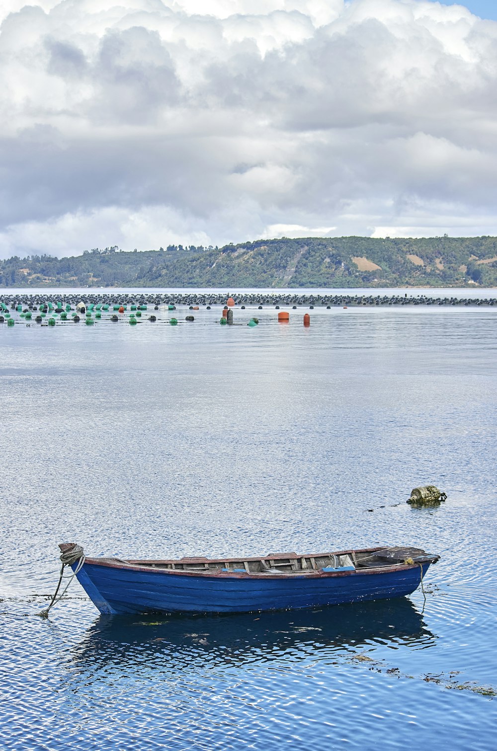 a blue boat floating on top of a large body of water