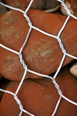 a close up of rocks behind a wire fence