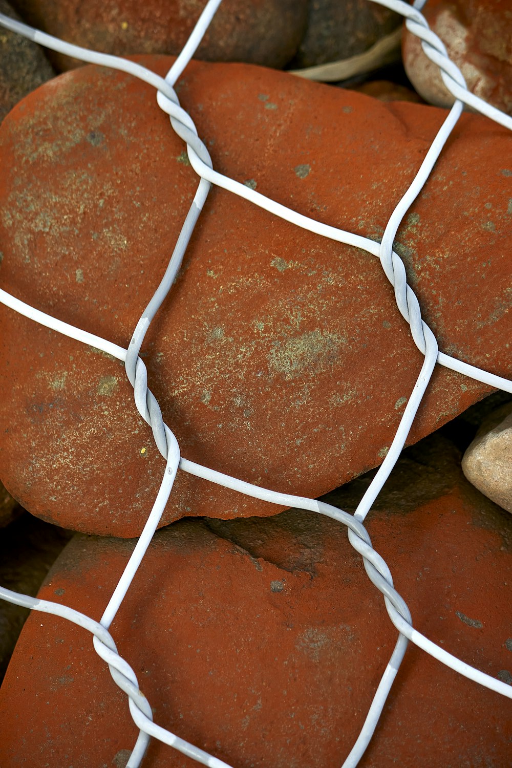 a close up of rocks behind a wire fence