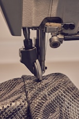 a close up of a sewing machine with a snake skin bag