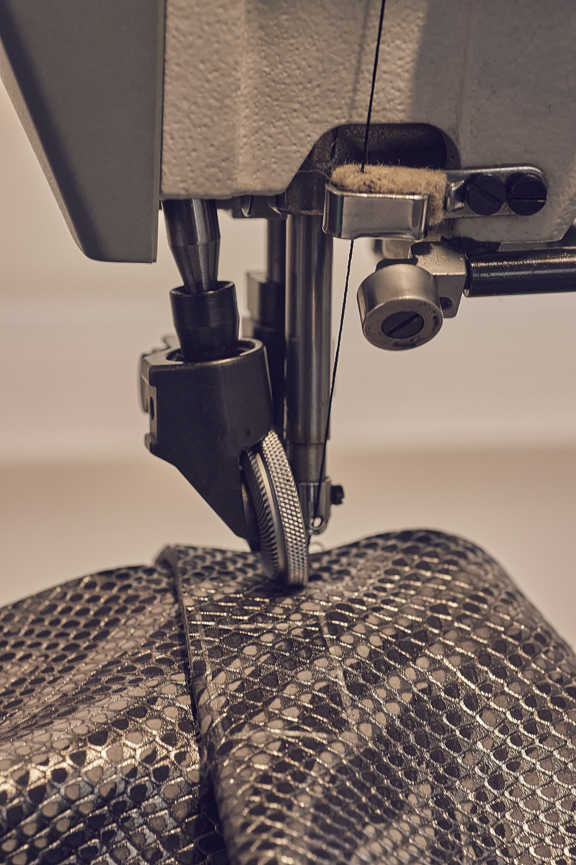 a close up of a sewing machine with a snake skin bag