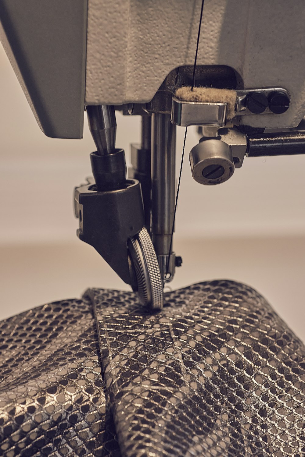 a close up of a sewing machine with a snake skin bag